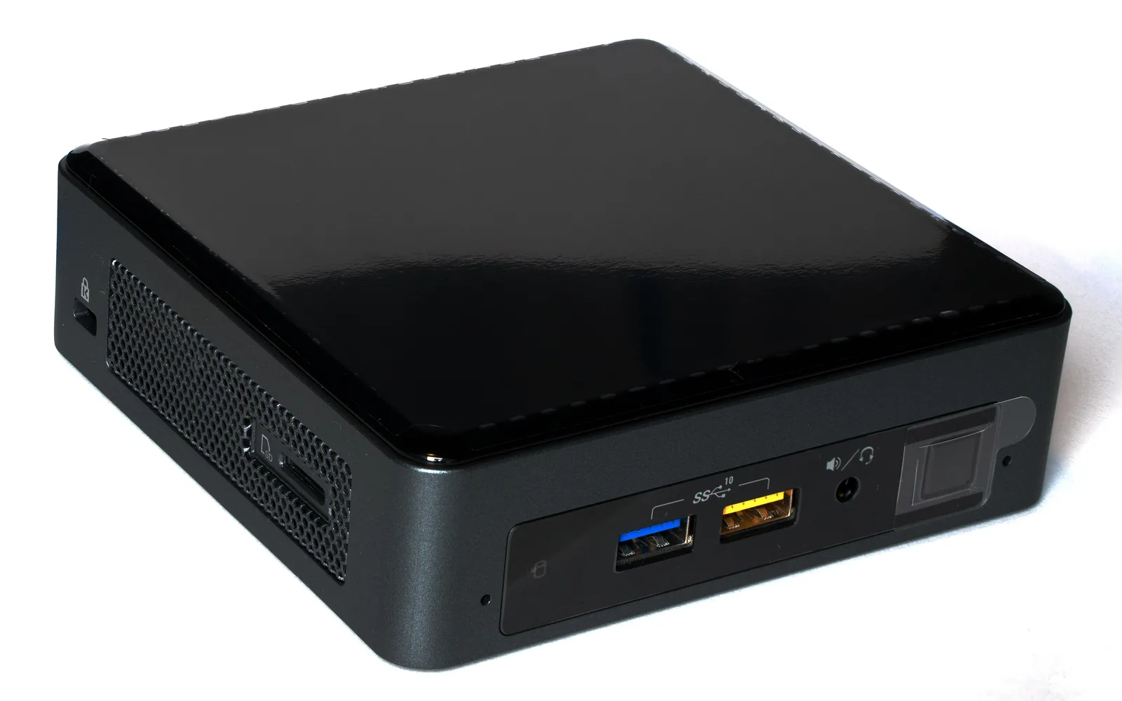 An Intel NUC8 mini PC photographed on white, angled to show its gloss black top panel, front USB ports and headphone jack