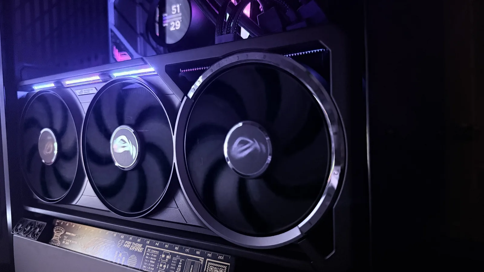 ASUS ROG Astral RTX 5080 OC installed in my own case, three Axial-tech fans facing out, the RGB top bar lit blue to purple