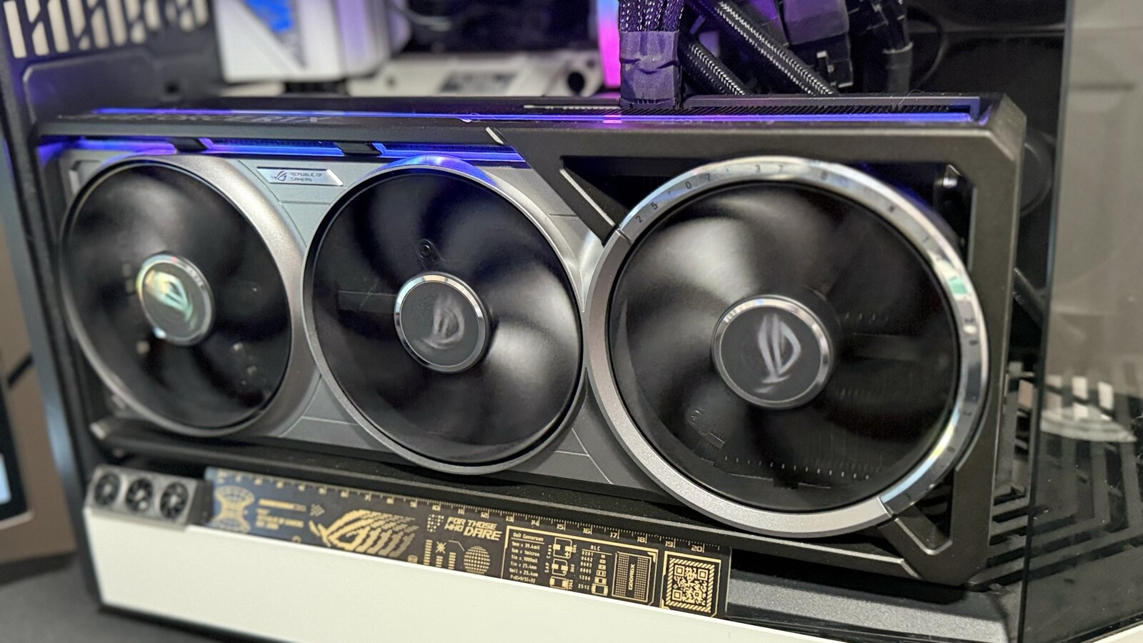 Side view of the ROG Astral RTX 5080 mounted in the ROG STRIX B650-A's PCIe 4.0 x16 slot, AIO tubes overhead, in the author's white case