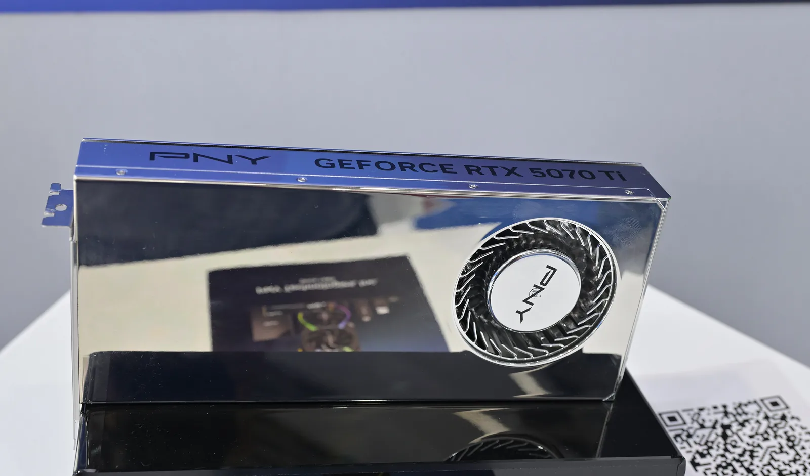 A PNY GeForce RTX 5070 Ti graphics card on a display plinth at Computex 2025, its model name printed along the top of the shroud